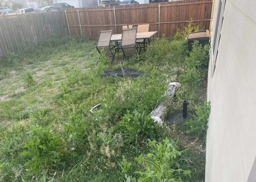 Back yard with old furniture and debris to be hauled away in Fort Worth, TX