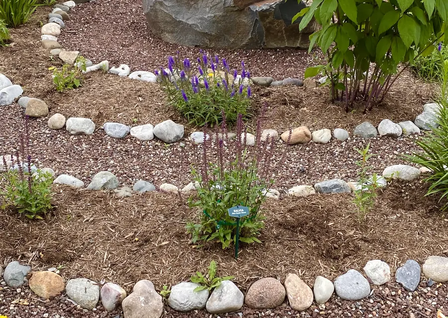 Fresh mulch laid through a stone-edged garden bed in Saginaw, TX