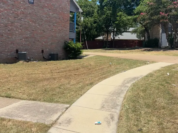 Mown front yard and clean sidewalk edge at a brick home