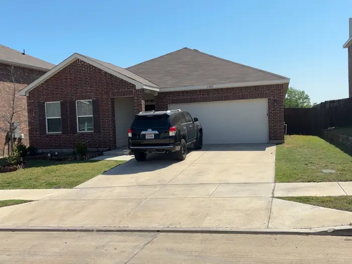 Brick home with the front lawn cut and the driveway blown clean