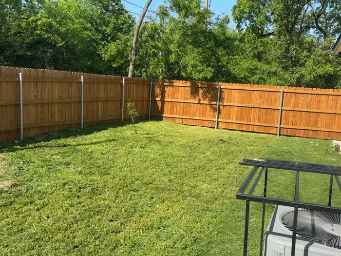 Tidy back yard lawn with new fence in Fort Worth, TX