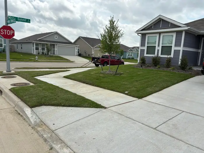 Corner lot lawn cut and edged by the stop sign