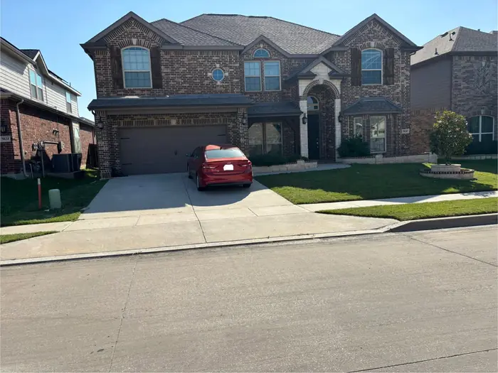 Two-story brick home with the front lawn and verge mowed