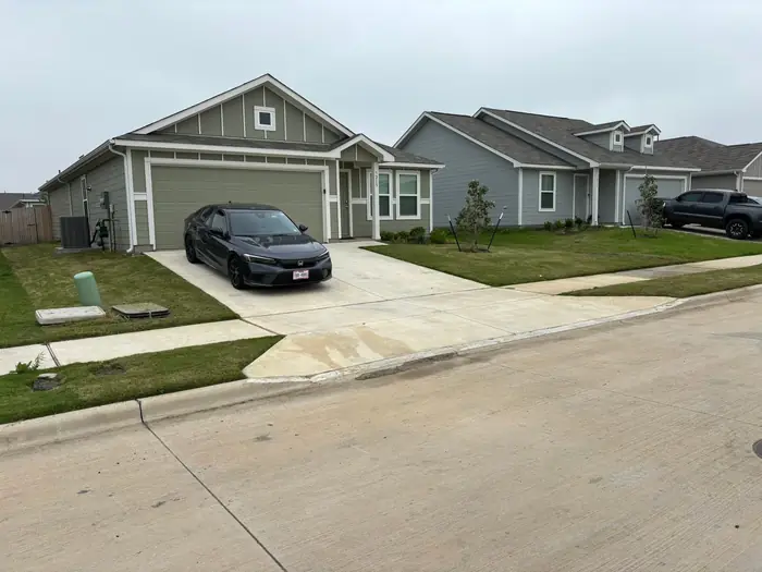 Newer home with the front lawn cut and driveway edges trimmed