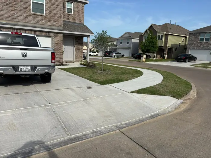Curved sidewalk and front lawn mown at a brick two-story home