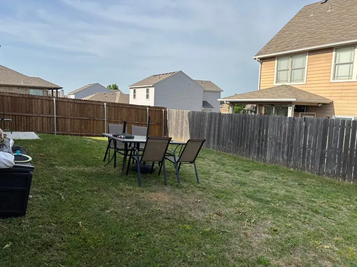 Back yard mowed around a patio table and chairs